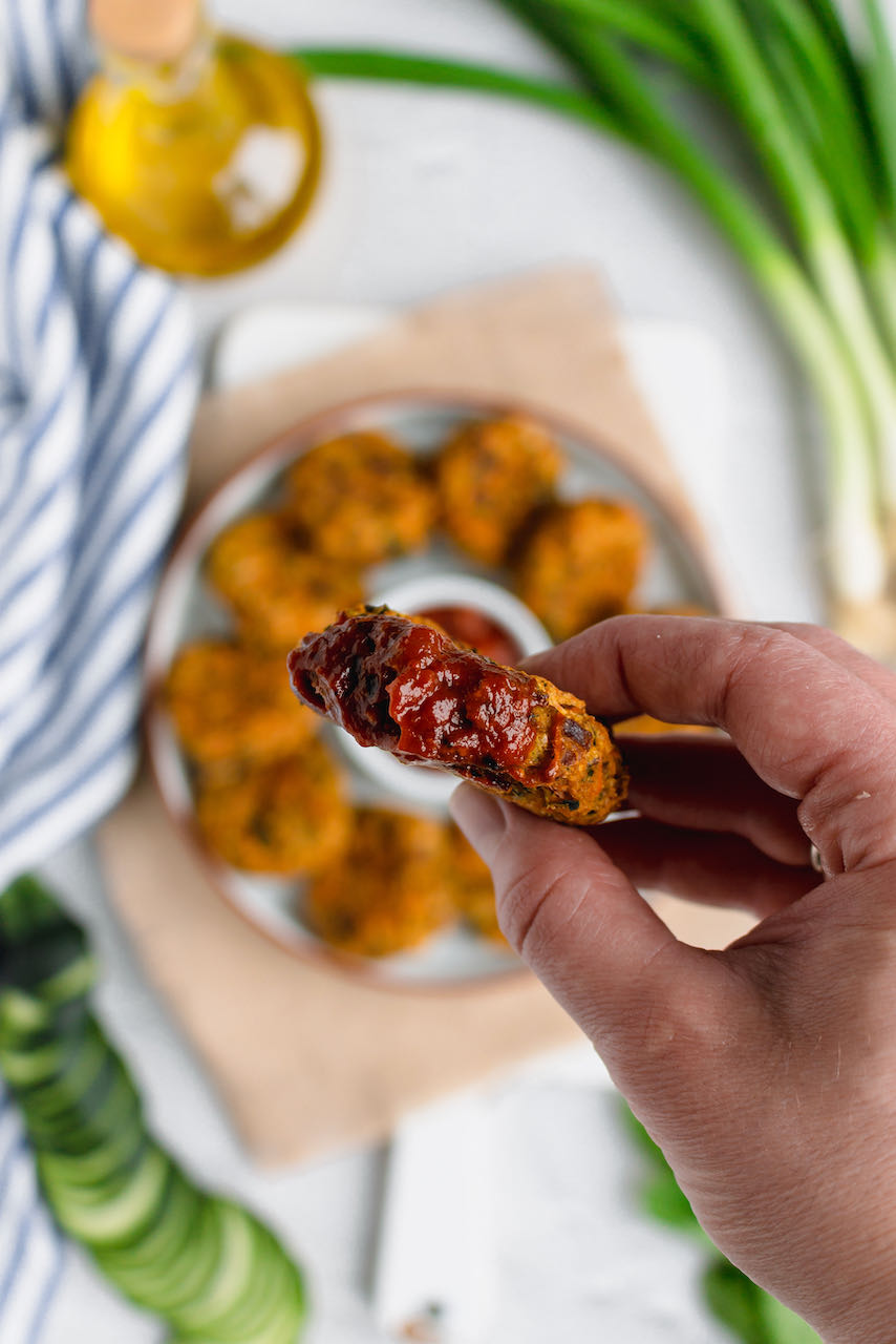 vegan zucchini carrot fritter dipped in the sauce