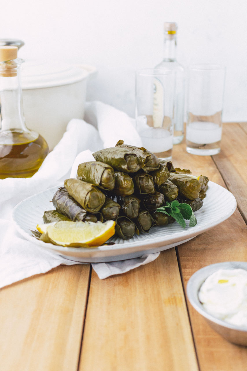 Dolmadakia gialantzi served in a platter and in the back is the pot